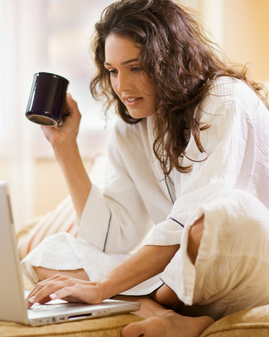 Insta (1) Autorin sitzt auf dem Boden. In der einen Hand hält sie einen Kaffe mit der anderen tippt sie auf ihrem Laptop herum.